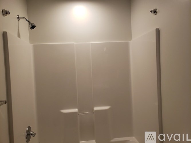 A bathroom with a glass shower door and a white door.