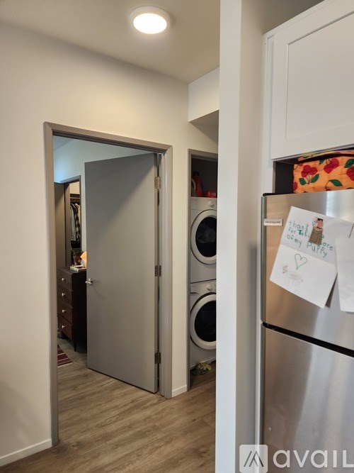 A kitchen with a refrigerator and a laundry room.