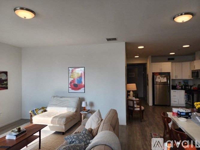A living room with a couch, chair, and a painting on the wall.