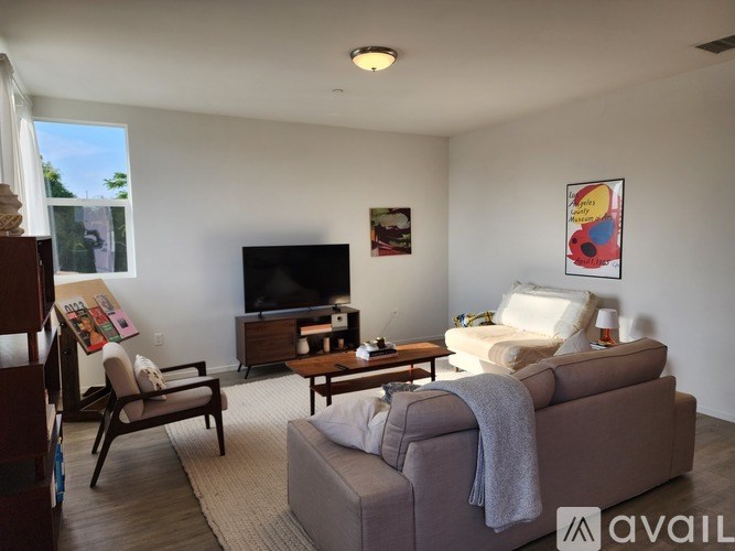 A living room with a couch, chair, and television.