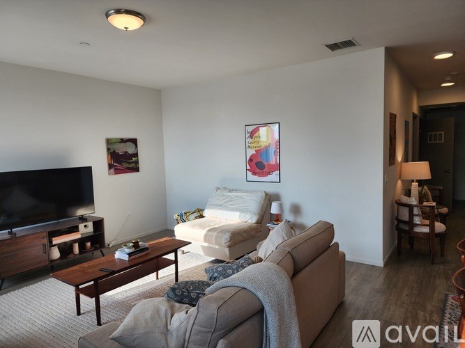 A living room with a couch, a coffee table, and a television.
