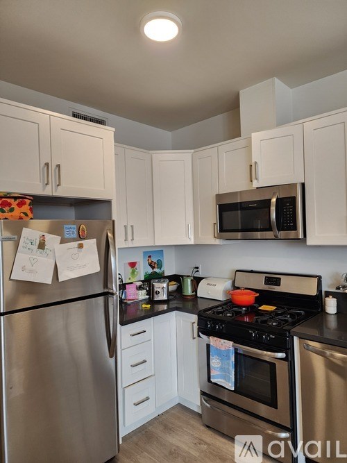 A kitchen with a stainless steel refrigerator, oven, and microwave.