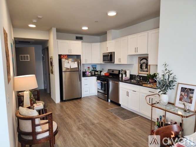 A kitchen with white cabinets and a wooden floor.