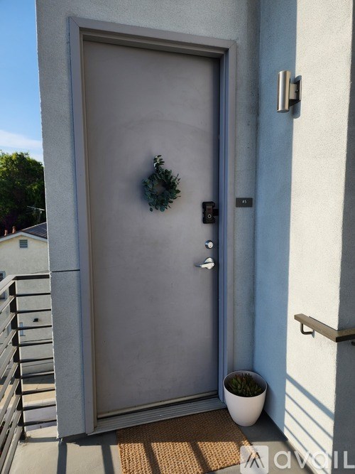 A grey door with a wreath on it.
