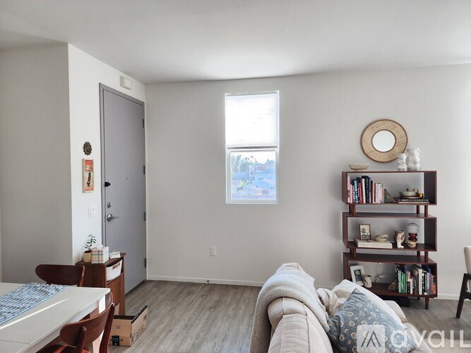 A living room with a couch, a dining table, and a bookshelf.