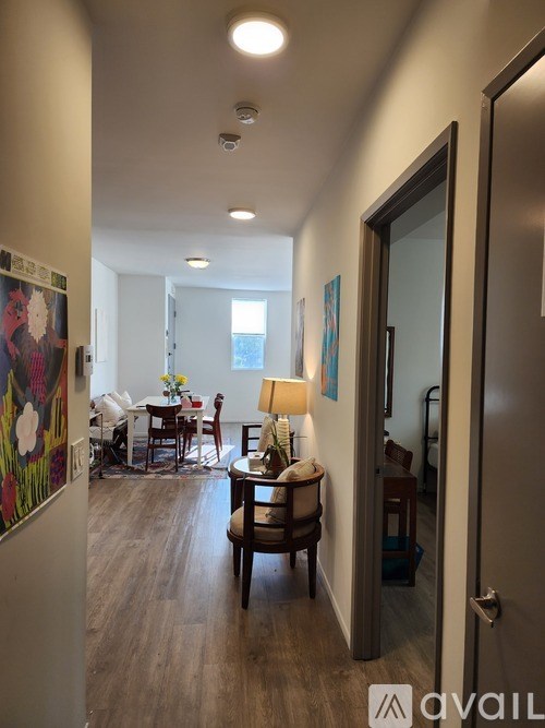 A hallway with a table and chairs in the background.