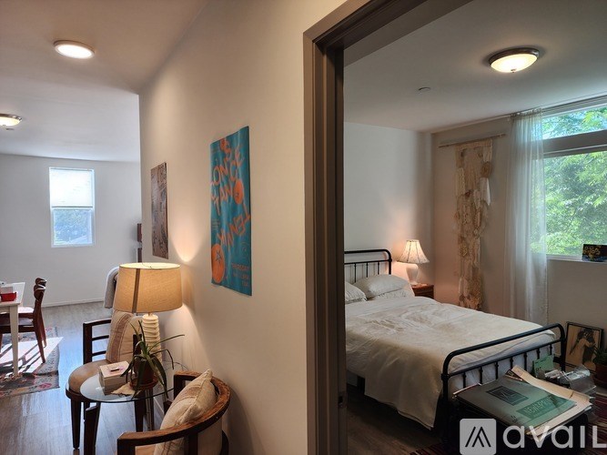 A bedroom with a bed, nightstand, and lamp.