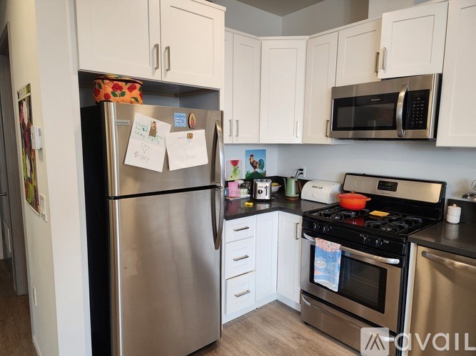 A kitchen with a refrigerator, oven, and microwave.