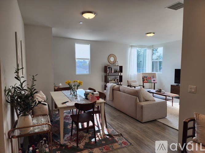 A living room with a couch, chairs, and a dining table.