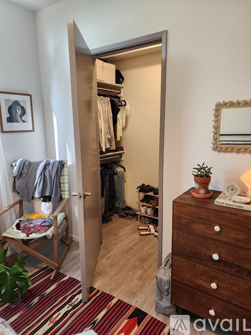 A room with a wardrobe and a chair with a cushion on it.