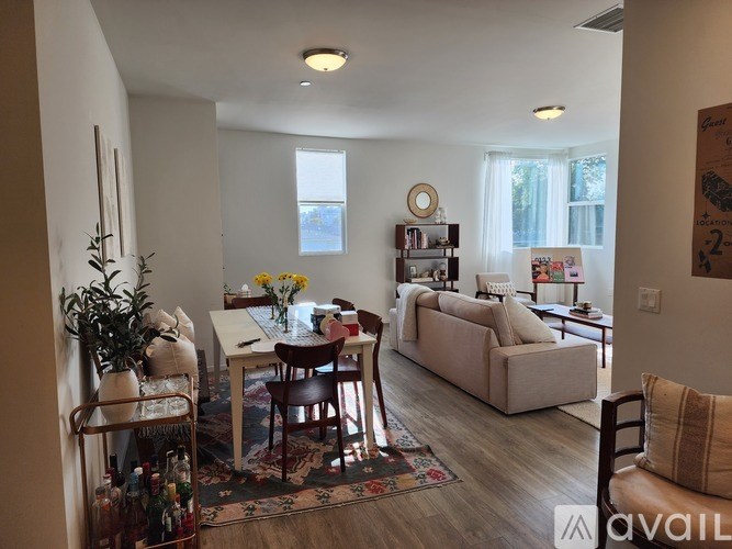 A living room with a couch, chairs, and a table with flowers on it.