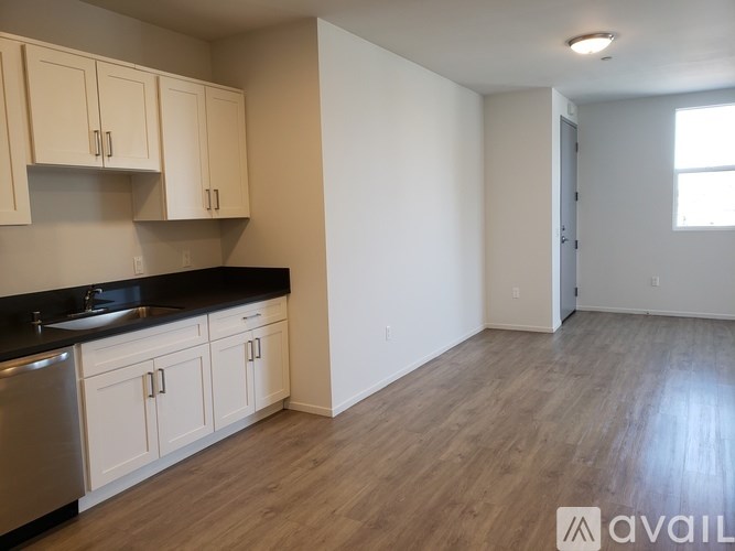 A kitchen with white cabinets and a black countertop.