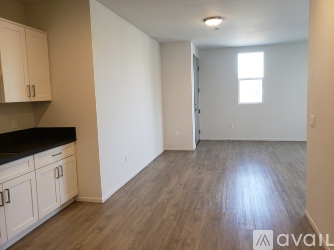 A room with wooden flooring and white walls.