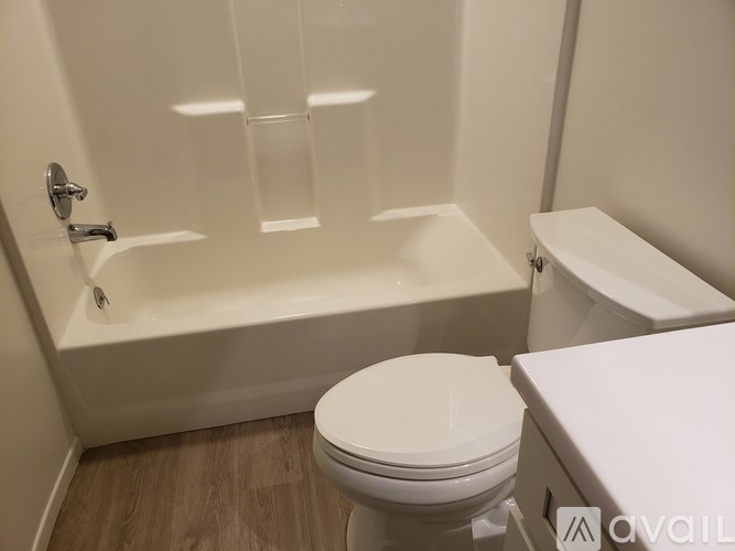 A white toilet sits next to a bathtub in a bathroom.