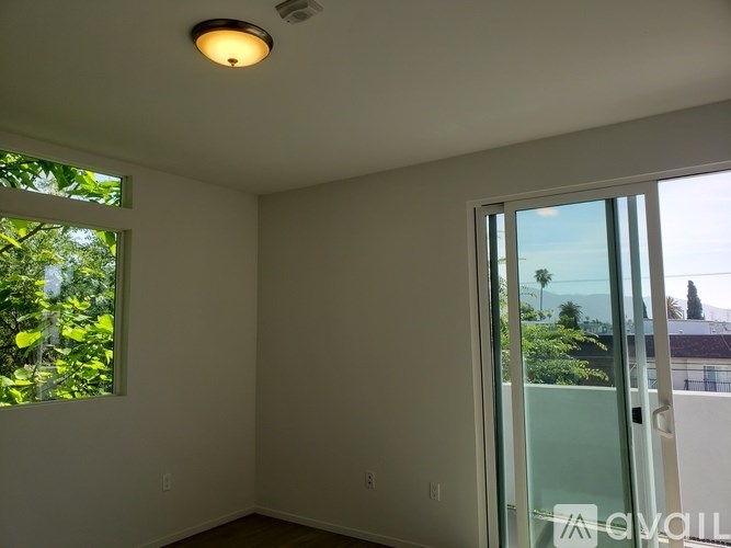 A room with a window and a door leading outside.