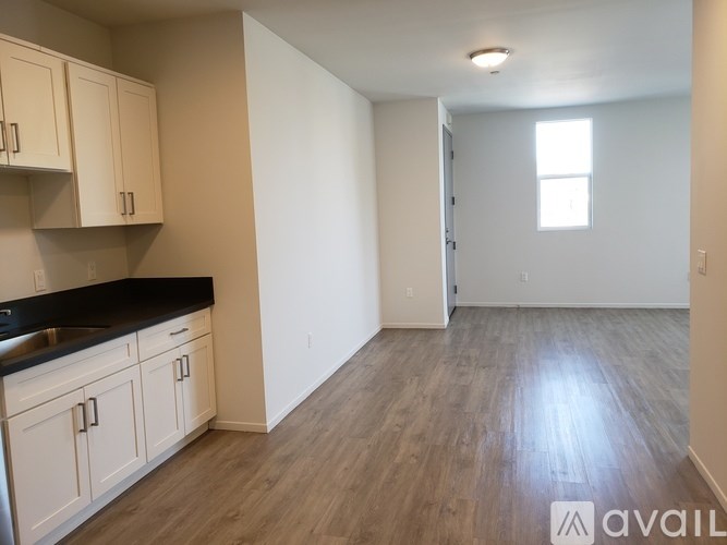 A kitchen with white cabinets and a black countertop.
