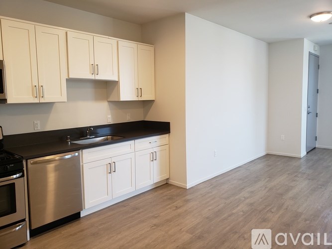 A kitchen with white cabinets and a black countertop.
