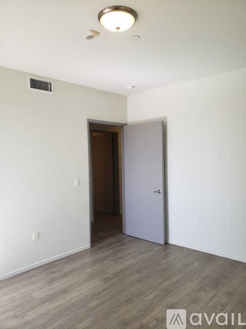 A room with a white wall and a grey door.