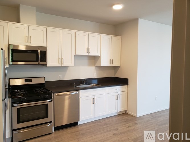 A kitchen with white cabinets and a black countertop.
