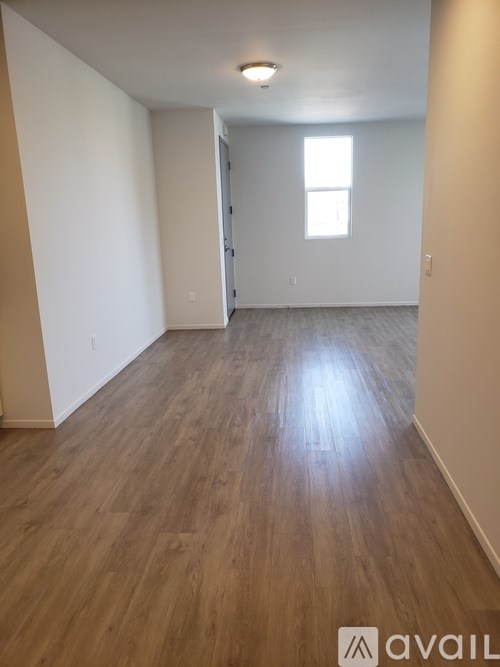 A room with wooden flooring and a window.