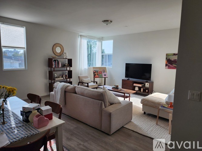 A living room with a couch, a chair, a coffee table, a television, and a bookshelf.