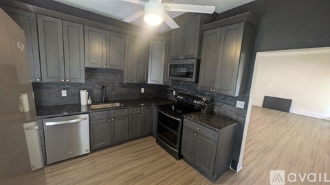 A kitchen with dark wood cabinets and a black stove top oven.