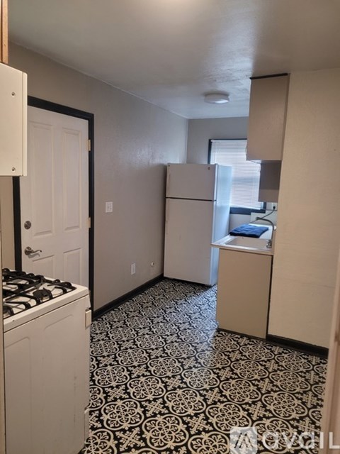 A kitchen with a black and white floor.