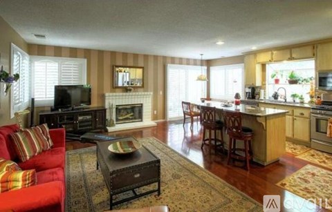 A living room with a red couch and a fireplace.