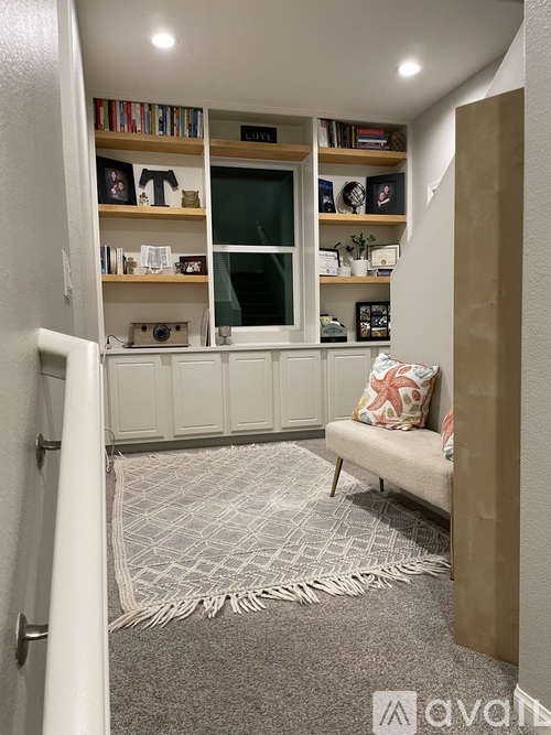 A living room with a couch, a rug, and a bookshelf.