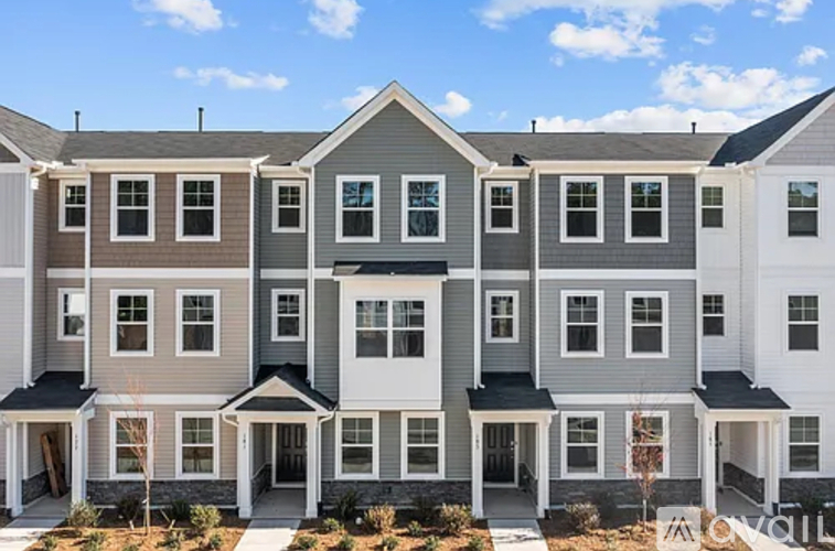 A row of townhouses with a clear blue sky above them.