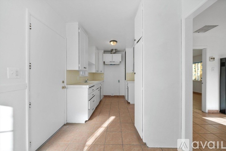 A kitchen with white appliances and cabinets.