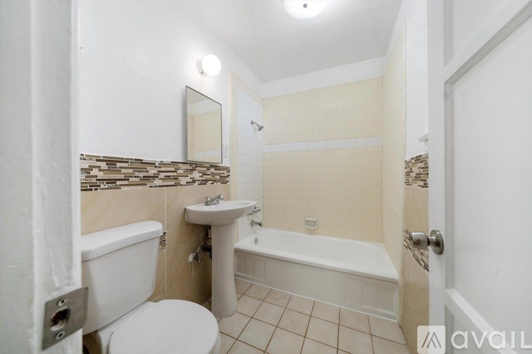 A bathroom with a toilet, sink, and bathtub.