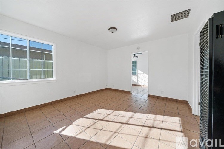 A room with tiled flooring and a window with blinds.