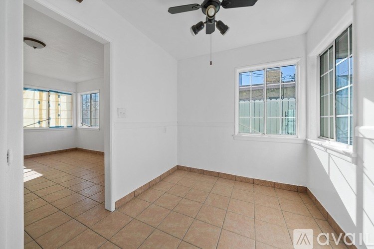 A room with a ceiling fan and tiled flooring.