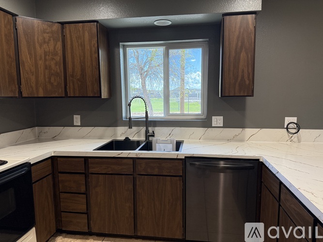 A kitchen with wooden cabinets and a stainless steel dishwasher.