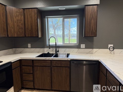 A kitchen with wooden cabinets and a stainless steel dishwasher.