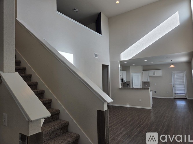 A spacious living room with a staircase leading to the upper floor.