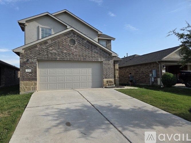 A house with a garage door and a driveway in front.