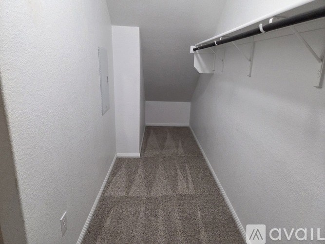 A small, empty room with a carpeted floor and white walls.