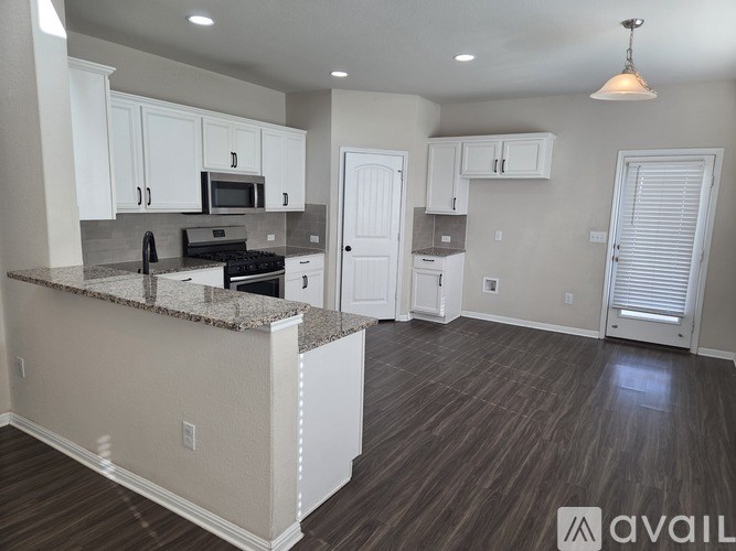 A kitchen with a granite countertop and white cabinets.