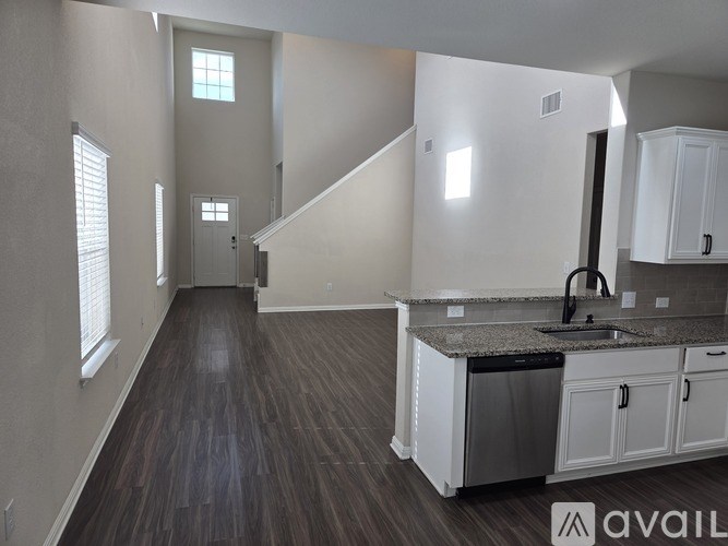 A kitchen with white cabinets and a granite countertop.