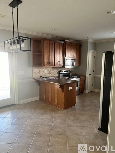 A kitchen with wooden cabinets and a black fridge.