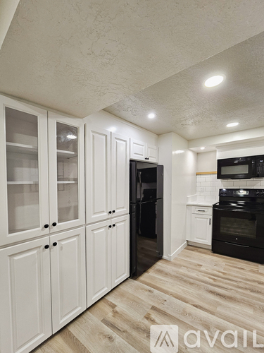 A kitchen with a wooden table and a black door.