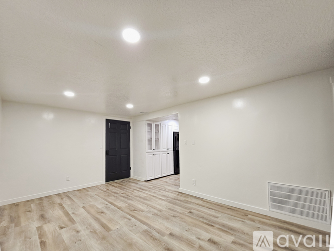 A long hallway with a black door on the right.