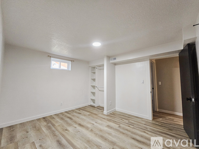 A bedroom with a bed, nightstand, and a staircase on the left side.