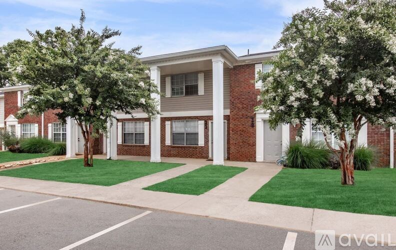 A modern two-story house with a front yard and trees.