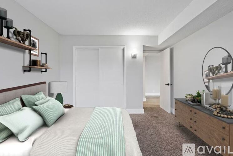 A bedroom with a bed, nightstand, and a mirror.