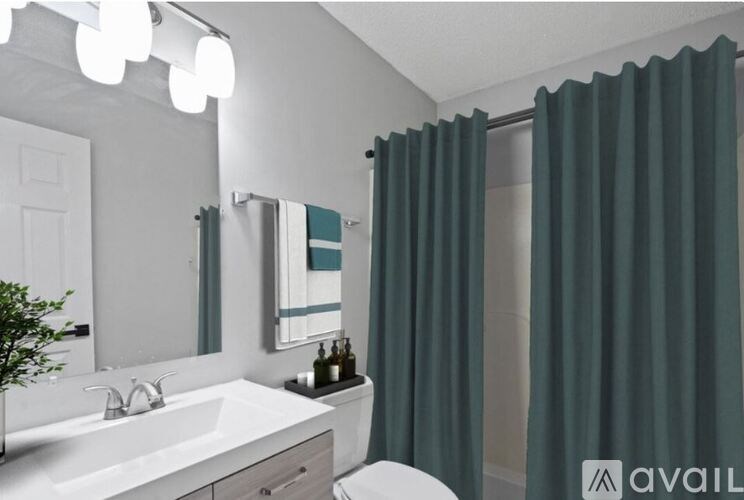 A bathroom with a white sink and green curtains.