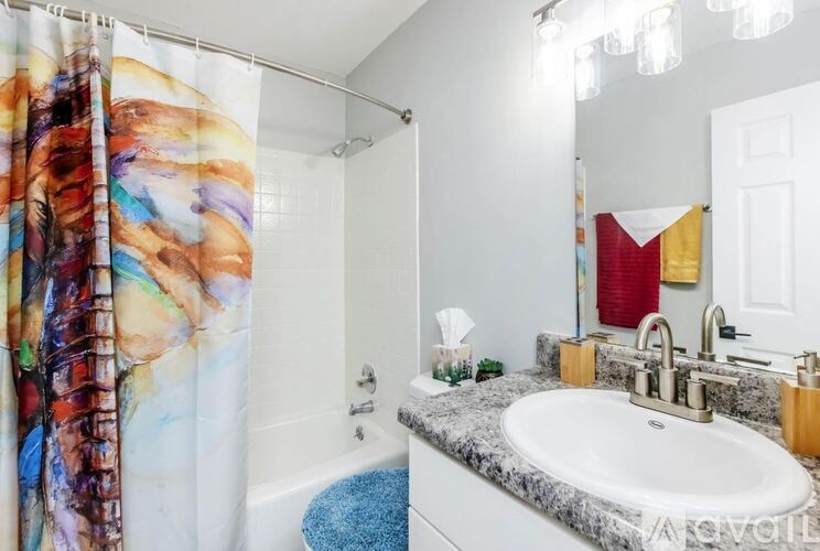 A bathroom with a shower curtain and a sink.