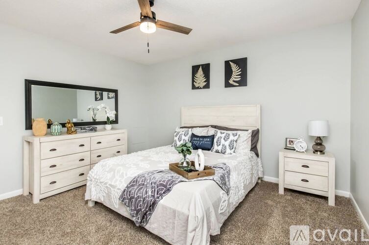 A bedroom with a bed, dresser, and mirror.